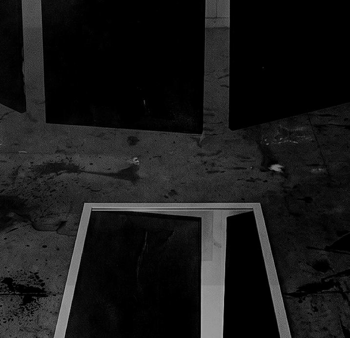 Paneles negros colgados en un taller sobre piso manchado