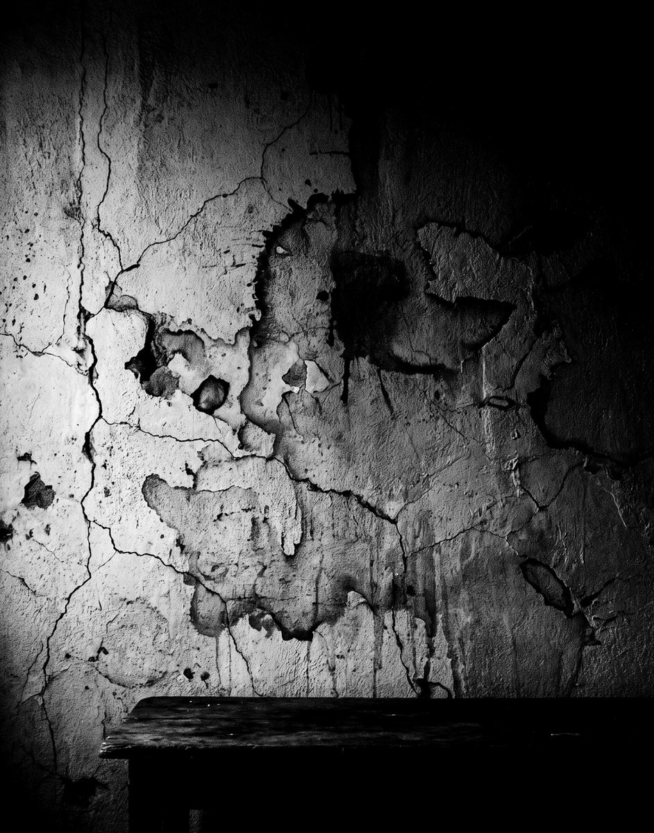 Pared descascarada con manchas, fotografiada en blanco y negro